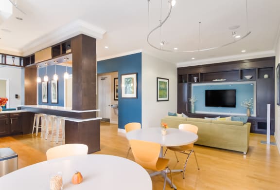 Clubhouse with ample seating, a couch and TV in Wynnfield Lakes apartments in Jacksonville, FL