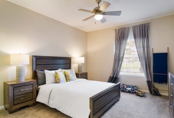 Bedroom in model apartment with plush carpeting and a ceiling fan in Wynnfield Lakes apartments in Jacksonville, FL