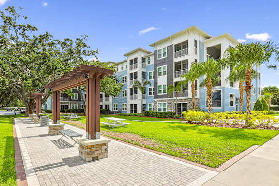Bench seating by sidewalks and apartment buildings at Dunedin Commons apartments in Dunedin, FL
