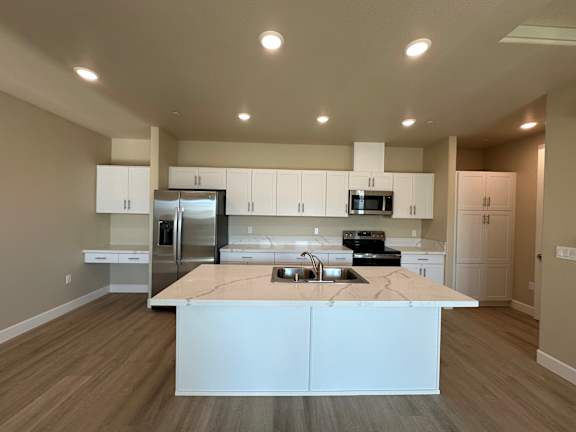 A kitchen with a granite countertop and white cabinets.