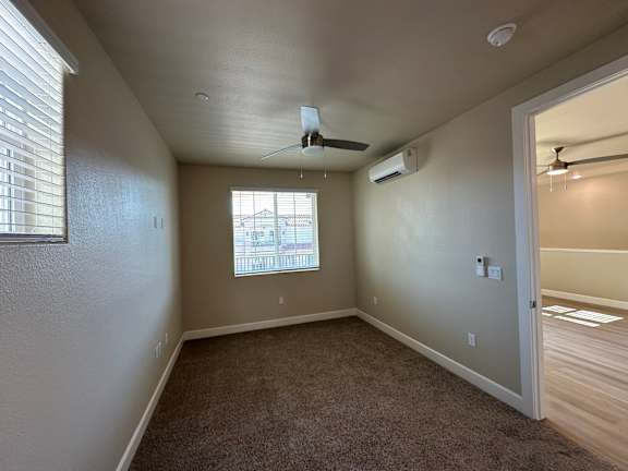 A room with a ceiling fan and a window.