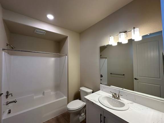 A white bathroom with a toilet, sink, and bathtub.