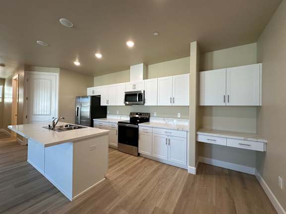 A kitchen with white cabinets and appliances.