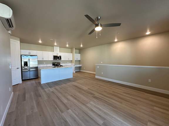 A spacious kitchen with a refrigerator, microwave, and oven.
