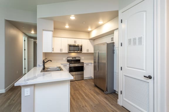 a kitchen with white cabinets and stainless steel appliances