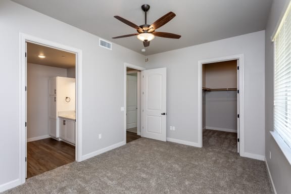 a bedroom with a ceiling fan and two doors