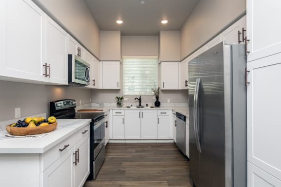 a kitchen with white cabinets and stainless steel appliances