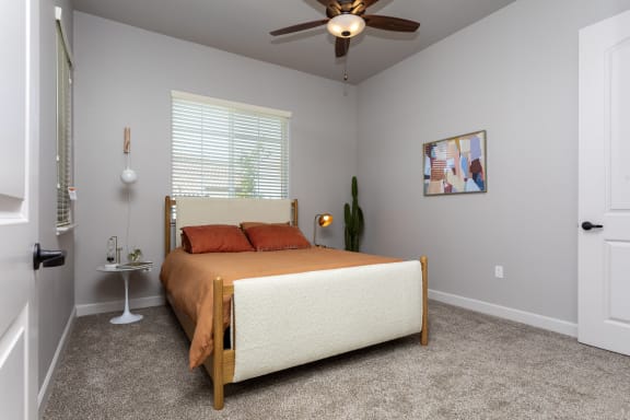 a bedroom with a bed and a ceiling fan