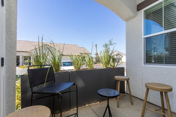 a small patio with two stools and two tables