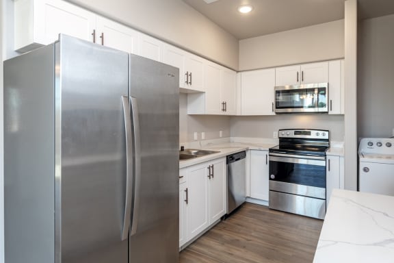 a kitchen with white cabinets and stainless steel appliances