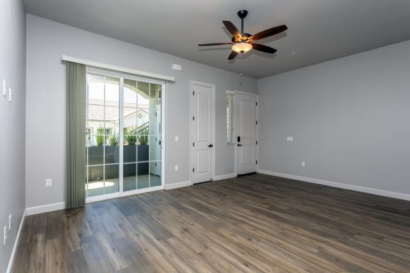 an empty living room with a ceiling fan