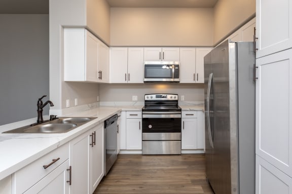 a kitchen with white cabinets and stainless steel appliances