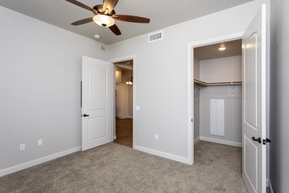 a bedroom with a ceiling fan and closet