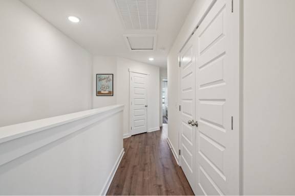 A hallway with white doors and a framed picture on the wall.