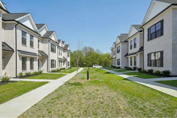 A row of houses with a grassy area in the foreground.