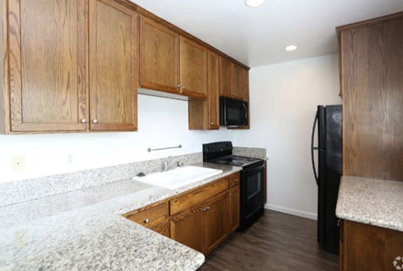 a kitchen with granite countertops and wooden cabinets