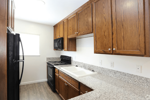 a kitchen with wooden cabinets and granite counter tops