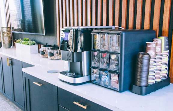 Coffee station with espresso machine and cup dispensers at Skyline at Barton Creek Apartments, Austin, TX