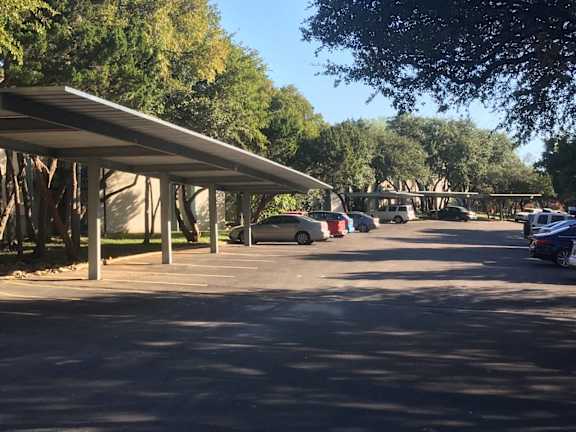 Covered carport parking with tree lined surroundings at Skyline at Barton Creek Apartments, Austin, 78758