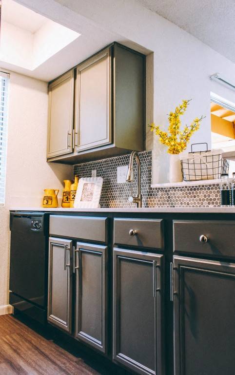 Modern kitchen with dark cabinets and mosaic backsplash at Skyline at Barton Creek Apartments, Austin, Texas