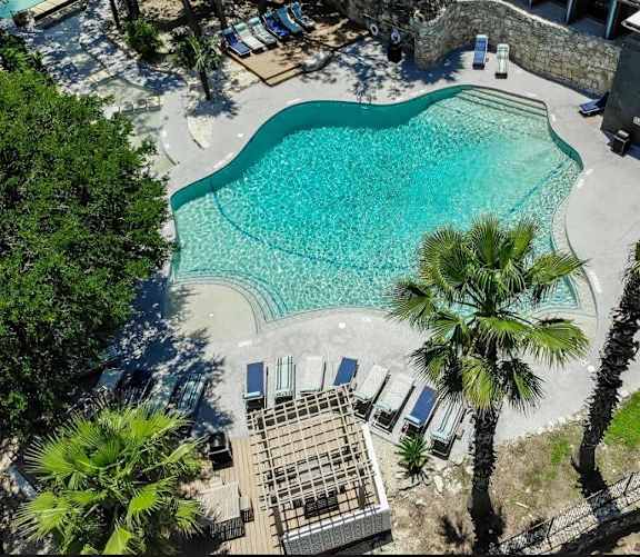 Aerial view of freeform pool with sun deck at Skyline at Barton Creek Apartments, Austin, 78758