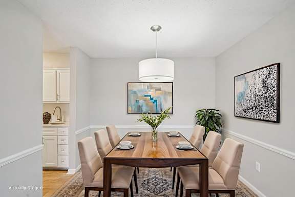 A dining room with a wooden table and chairs.