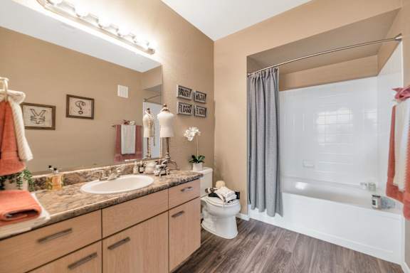 a bathroom with a large mirror and a sink and a toilet at Montage at Pecos Ranch Apartments, Chandler, 85286