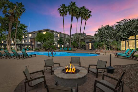 pool with a fire pit at dusk at Montage at Pecos Ranch Apartments, Chandler, AZ