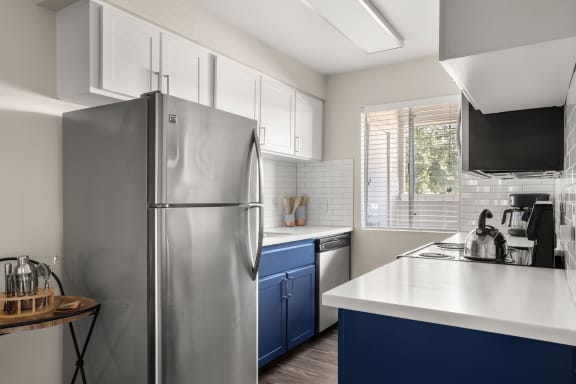 a kitchen with white countertops and blue cabinets