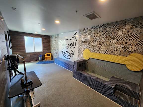A room with a yellow bench and a wall with a patterned design.
