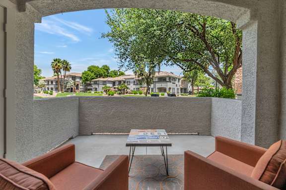 a patio with couches and a table in front of a window at Montage at Pecos Ranch Apartments, Chandler