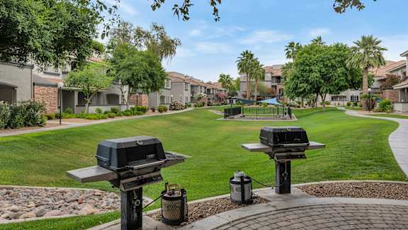 two hot dogs sitting on a grill in a park at Montage at Pecos Ranch Apartments, Chandler, Arizona
