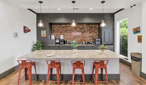 a kitchen with a marble counter top and bar stools at Montage at Pecos Ranch Apartments, Chandler