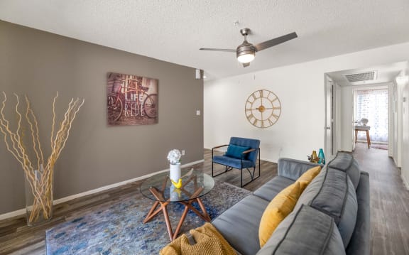 a living room with a couch and a table and a ceiling fan  at Glen Brae, Glendale, AZ, 85301