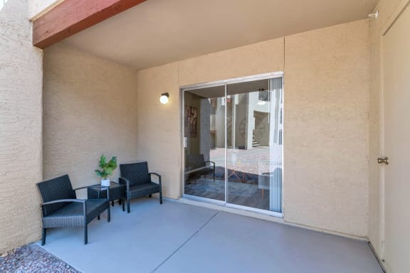 a patio with two chairs and a sliding glass door  at Glen Brae, Arizona