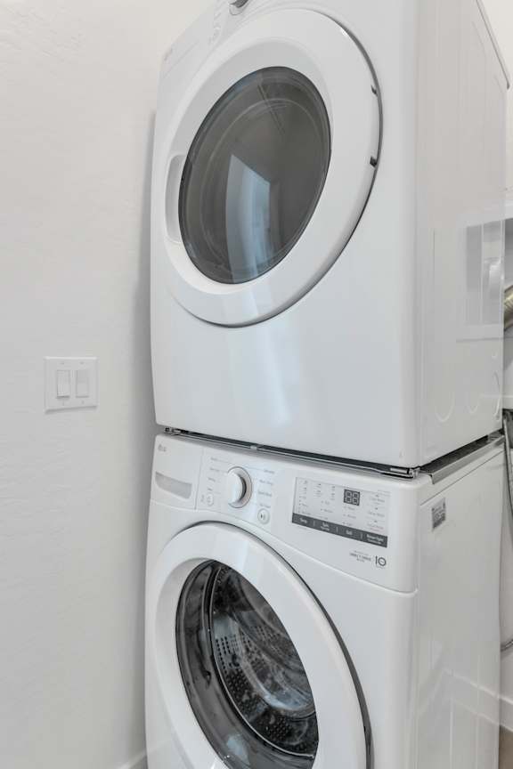 A white washing machine and dryer stacked on top of each other.