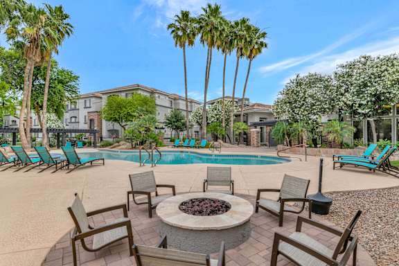 our apartments have a resort style pool with chairs and a fire pit at Montage at Pecos Ranch Apartments, Chandler