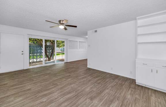 A room with a ceiling fan and wooden flooring at The Phoenix Apartments on 6th Avenue, Phoenix