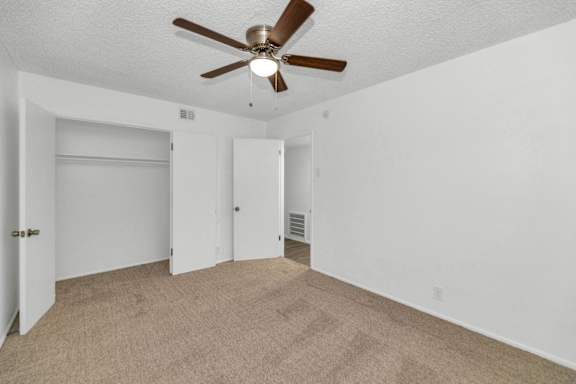 A room with a ceiling fan and carpeted floor at The Phoenix Apartments on 6th Avenue, Phoenix