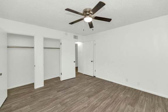 A room with a ceiling fan and wooden flooring at The Phoenix Apartments on 6th Avenue, Phoenix