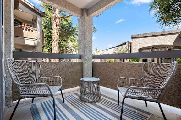 Two chairs and a table on a patio.