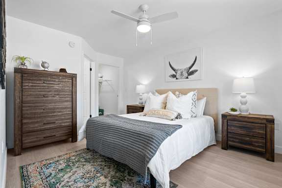 A bedroom with a bed, nightstands, and a rug.