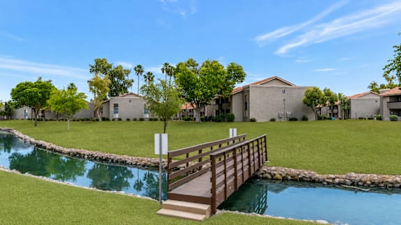 A small bridge over a pond in a residential area.