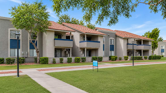 Apartment complex with a blue sign in front.