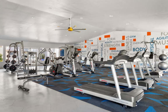 a large fitness room with cardio equipment and a ceiling fan at Denim Scottsdale, Scottsdale