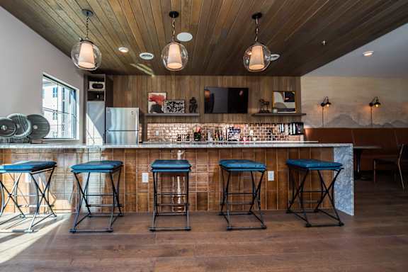 Four blue bar stools are in front of a bar at The Crossings  at Windsong, Prescott Valley, 86314