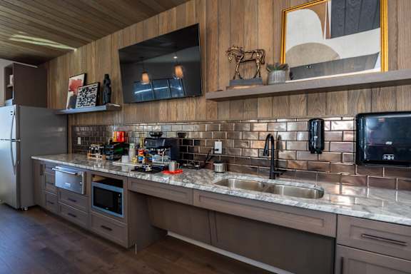 A modern kitchen with a wooden ceiling and a large island with a sink at The Crossings  at Windsong, Prescott Valley, 86314