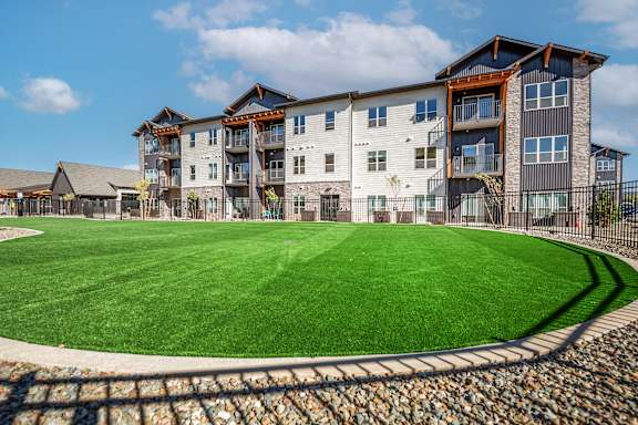 A large grassy area in front of a multi-story building at The Crossings  at Windsong, Prescott Valley, 86314