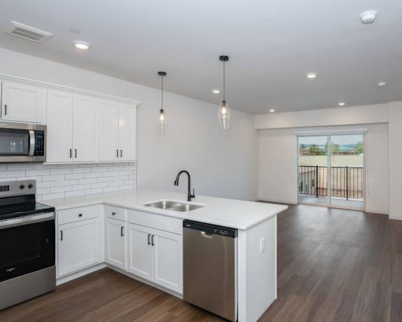 A modern kitchen with white cabinets and stainless steel appliances.