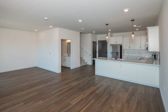 A kitchen with white cabinets and a wooden floor.